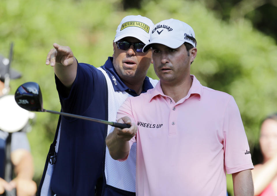 FILE - Kevin Kisner, right, listens to his caddie Duane Bock, before hitting on the 15th tee during the third round of The Players Championship golf tournament on May 9, 2015, in Ponte Vedra Beach, Fla. The American caddie will be part of Team Europe when he works for Sepp Straka of Austria in the Ryder Cup in Italy. (AP Photo/Chris O'Meara, File)