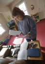 Regina Bachman looks through papers dealing flood insurance on her property inside her home in Loveland, Ohio on Friday, March 21, 2014. Bachman bought the home in September 2013 and was initially told by the bank that flood insurance on the property would be affordable, only to find out after closing that the rates were going to increase over $7,000 more annually with new premiums for the National Flood Insurance Program. (AP Photo/Al Behrman)