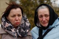 Alla Nechyporenko speaks with her neighbour Tetiana Shonia on a day of the first anniversary of Russia's attack on Ukraine, in Bucha