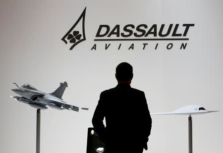 A visitor looks at replicas of the fighter jet Rafale (L) and Neuron on the Dassault booth during the European Business Aviation Convention & Exhibition (EBACE) at Cointrin airport in Geneva, Switzerland, in this picture taken on May 19, 2015. REUTERS/Denis Balibouse/Files