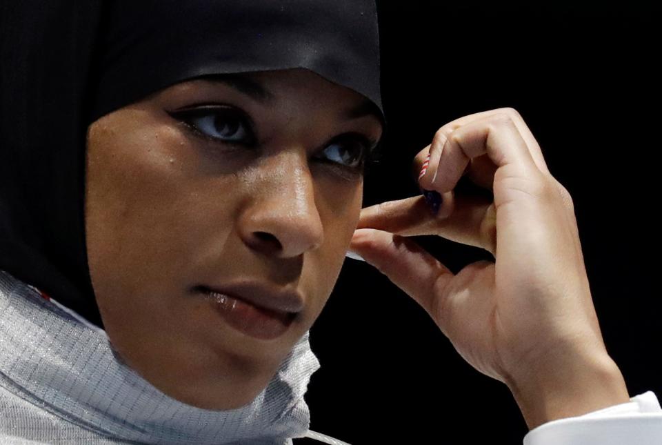 Ibtihaj Muhammad of the United States adjusts her hijab prior to competing in the women's individual saber fencing event at the 2016 Summer Olympics in Rio de Janeiro.