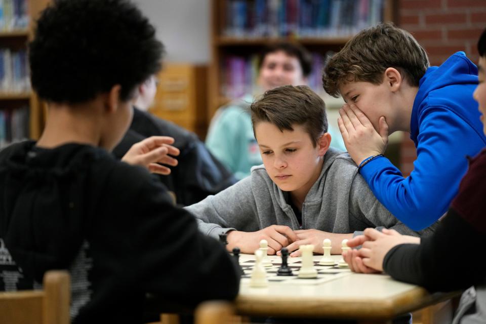 Owen Isenhour whispers advice to Eli Marquis during a Reeds Brook Middle School after-school chess practice, Tuesday, April 25, 2023, in Hampden, Maine. Part-time chess coach and full-time custodian David Bishop led his elementary and middle school teams to state championship titles this year.