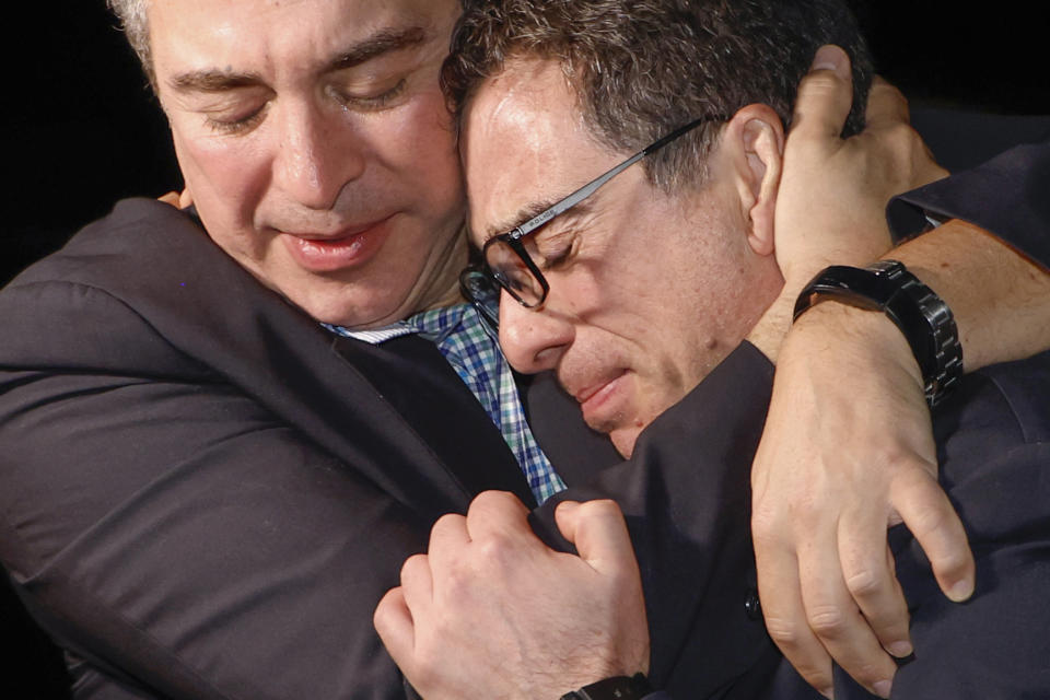 A family member embraces freed American Siamak Namazi after he and four fellow detainees were released in a prisoner swap deal and arrive at Davison Army Airfield, Tuesday, Sept. 19, 2003 at Fort Belvoir, Va. (Jonathan Ernst/Pool via AP)