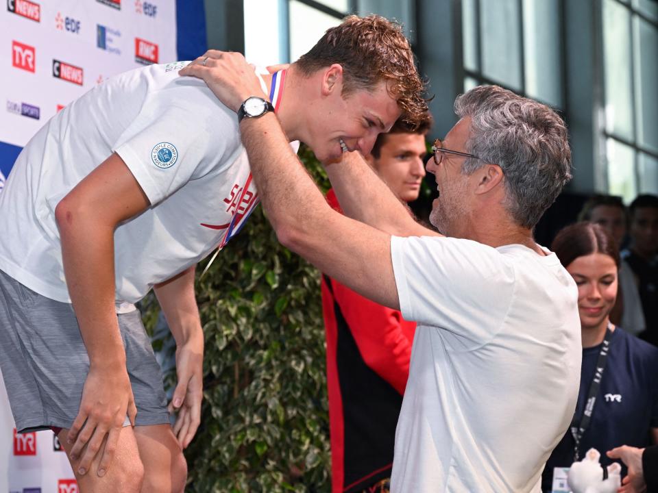 Leon Marchand receives a gold medal from his father and former swimmer Xavier Marchand
