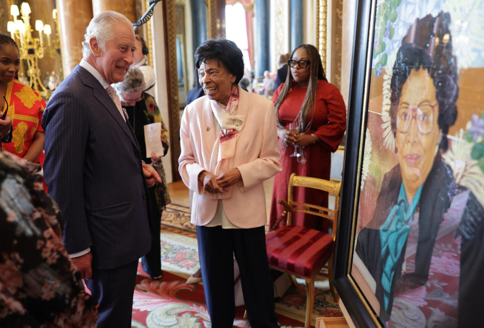 Britain's King Charles III (R) speaks with Linda Haye, alongside a portrait of them, during a reception to celebrate the Windrush Generation and mark the 75th anniversary of the arrival of the HMT Empire Windrush, at Buckingham Palace, in London, on June 14, 2023. During the reception, ten portraits of Windrush elders were unveiled. (Photo by Chris Jackson / POOL / AFP) (Photo by CHRIS JACKSON/POOL/AFP via Getty Images)