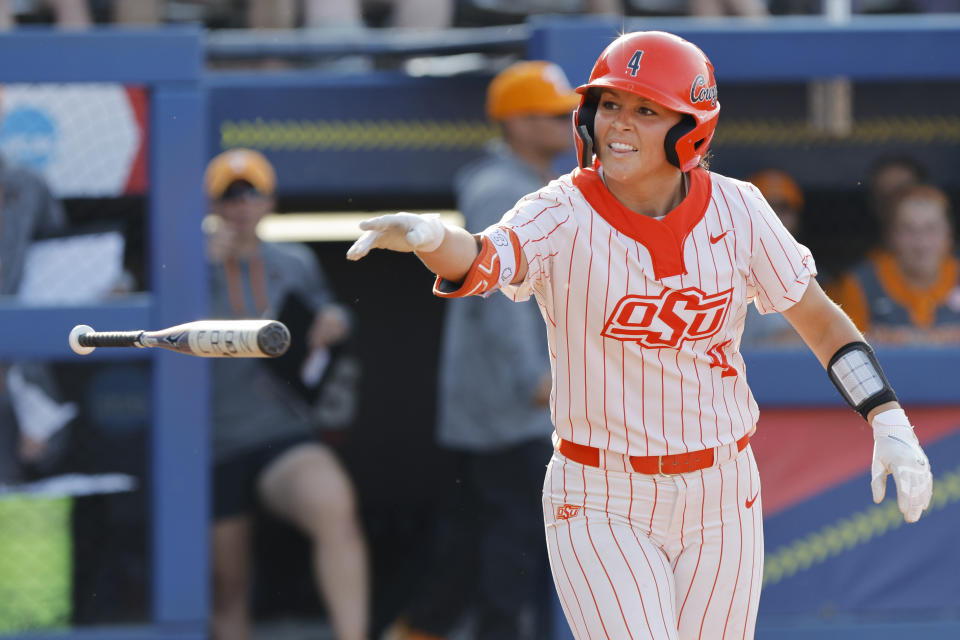 Oklahoma State's Taylor Tuck tosses her bat after drawing a walk against Tennessee during the second inning of an NCAA softball Women's College World Series game Sunday, June 4, 2023, in Oklahoma City. (AP Photo/Nate Billings)