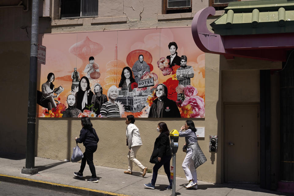 A group of women walk up Jackson Street in Chinatown past the new "AAPI Community Heroes" mural in San Francisco, Monday, May 23, 2022. Chinatowns and other Asian American enclaves across the U.S. are using art and culture to show they are safe and vibrant hubs nearly three years after the start of the pandemic. From an inaugural arts festival in San Francisco to night markets in New York City, the rise in anti-Asian hate crimes has re-energized these communities and drawn allies and younger generations of Asian and Pacific Islander Americans. (AP Photo/Eric Risberg)