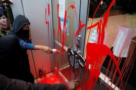 Demonstrators splash red paint on a door outside Oakland Police headquarters during a protest against the police shootings that lead to two deaths in Louisiana and Minnesota, respectively, in Oakland, California, U.S. July 7, 2016. REUTERS/Stephen Lam