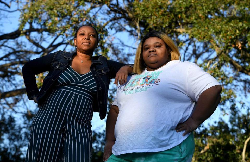 Sisters Maya and Malekia McKinney stand in the setting sun on the property where they grew up in St. Petersburg. The home is no longer there. The city bought the property after it was foreclosed upon for unpaid code enforcement fines.