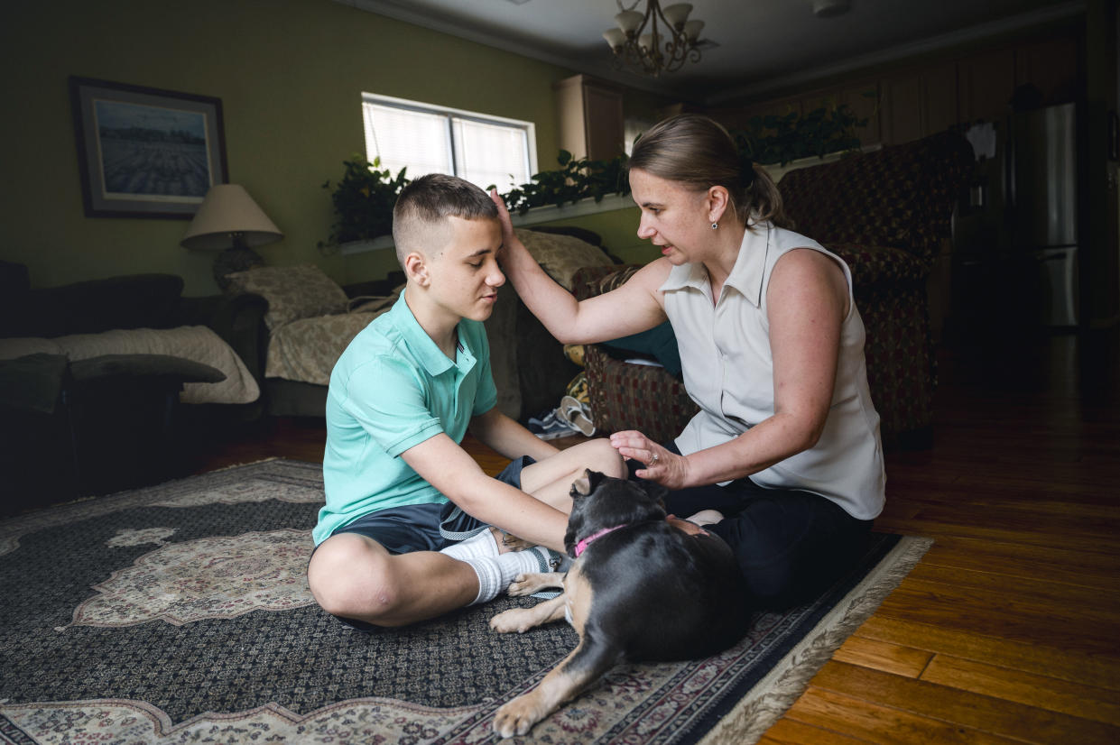 Anna Lazos with her son and their dog at home in Egg Harbor Township, N.J., on June 27, 2024. (Hannah Yoon/The New York Times)