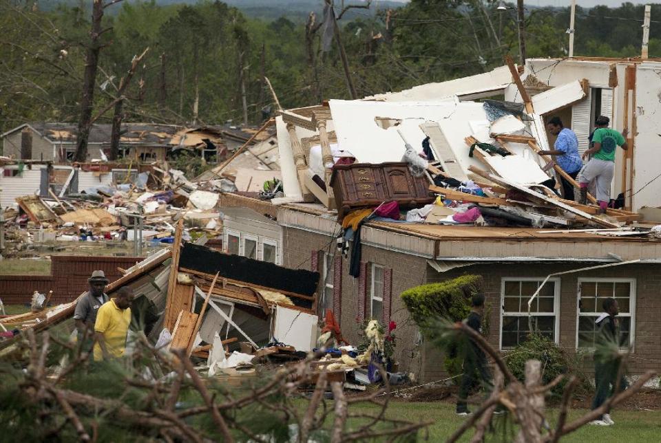 Anisa Baker-Busby and Kiara Williams look though Anisa's mothers home for insurance papers on Tuesday, April 29, 2014, in Salem, Ala. A dangerous storm system that spawned a chain of deadly tornadoes killed dozens from the Midwest to the Deep South. (AP Photo/Opelika-Auburn News, Albert Cesare)