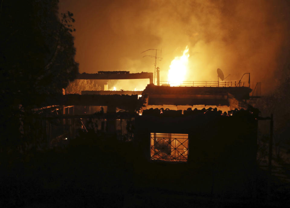 A house burns in the town of Mati, east of Athens, Monday, July 23, 2018. Regional authorities have declared a state of emergency in the eastern and western parts of the greater Athens area as fires fanned by gale-force winds raged through pine forests and seaside settlements on either side of the Greek capital. (AP Photo/Thanassis Stavrakis)