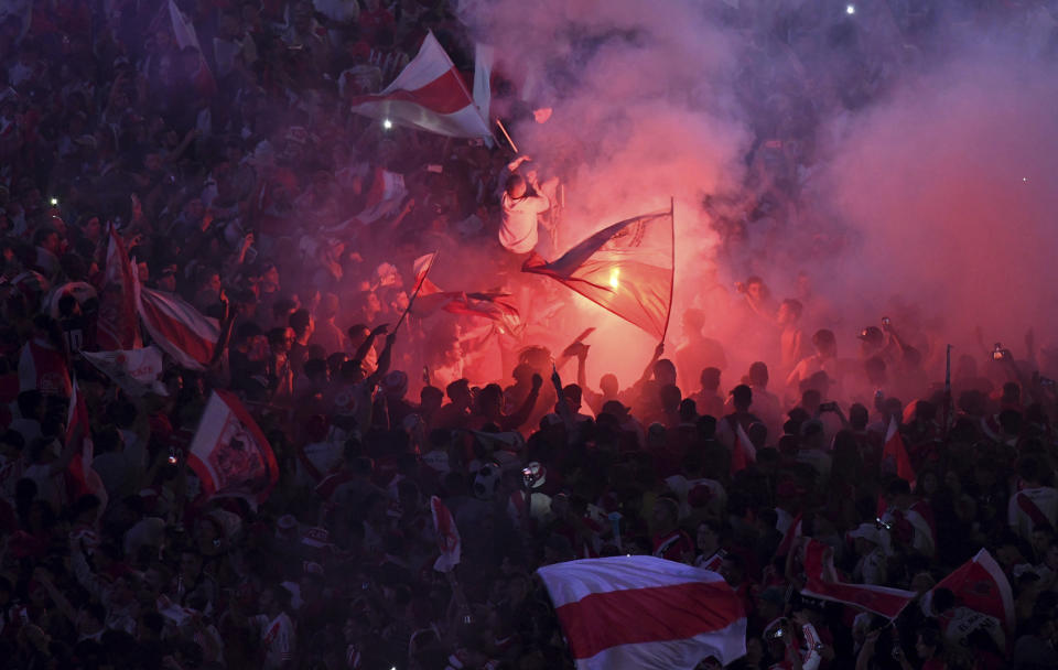 River Plate soccer fans celebrate with flags and flares their team's 3-1 victory over Boca Juniors and clenching the Copa Libertadores championship title, at the Obelisk in Buenos Aires, Argentina, Sunday, Dec. 9, 2018. The South American decider was transferred from Buenos Aires to Madrid, Spain after River fans attacked Boca's bus on Nov. 10 ahead of the second leg. (AP Photo/Gustavo Garello)