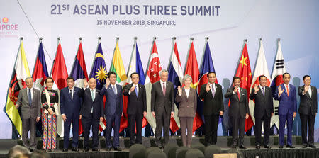 Japan's Prime Minister Shinzo Abe (5L), Chinese Premier Li Keqiang (6L), Singapore's Prime Minister Lee Hsien Loong (C) and South Korea's Foreign Minister Kang Kyung-Wha (6R) pose for a group photo with other Asean leaders at the ASEAN Plus Three (APT) Summit in Singapore, November 15, 2018. REUTERS/Athit Perawongmetha, November 15, 2018. REUTERS/Athit Perawongmetha