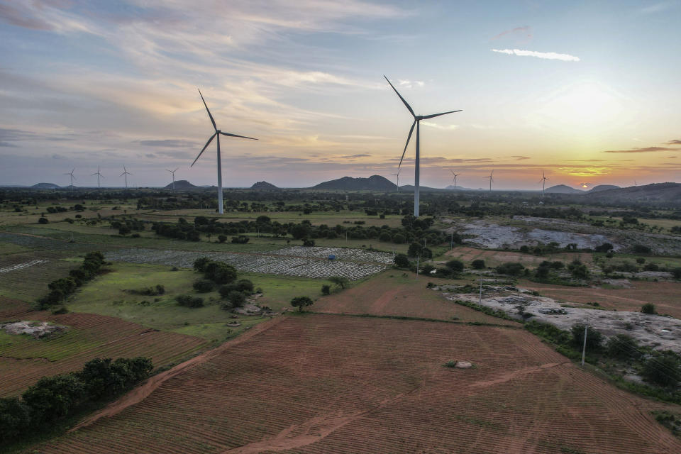 A windmill farm works as the sun sets in Anantapur district, Andhra Pradesh, India, Wednesday, Sept 14, 2022. India is investing heavily in renewable energy and has committed to producing 50% of its power from clean energy sources by 2030. (AP Photo/Rafiq Maqbool)