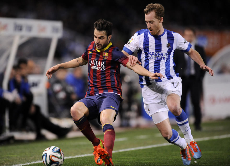 FC Barcelona's Francesc Fabregas, left , tries to control the ball in front with Real Sociedad's David Zurutuza, during their Spanish Copa del Rey semifinal second leg soccer match, at Anoeta stadium, in San Sebastian northern Spain, Wednesday, Feb. 12, 2014. (AP Photo/Alvaro Barrientos)