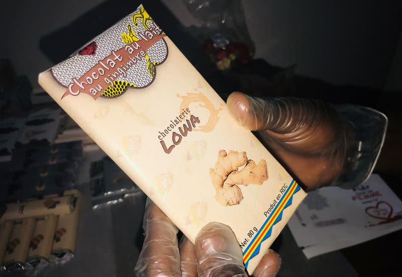 A worker holds a packaged bar of chocolate at the Lowa Chocolate Factory in Goma