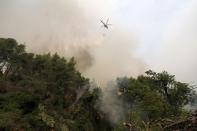 An helicopter drops water during a wildfire near Kechries village on the island of Evia, about 144 kilometers (90 miles) north of Athens, Greece, Thursday, Aug. 5, 2021. Forest fires fueled by a protracted heat wave raged overnight and into Thursday in Greece, threatening the archaeological site at the birthplace of the modern Olympics and forcing the evacuation of dozens of villages. (AP Photo/Thodoris Nikolaou)