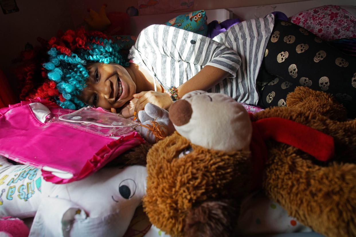 Trinity Neal lays amongst her many plush stuffed animals and pillows on her bunk bed. Trinity discovered she was a girl in a boy's body when she was 3.