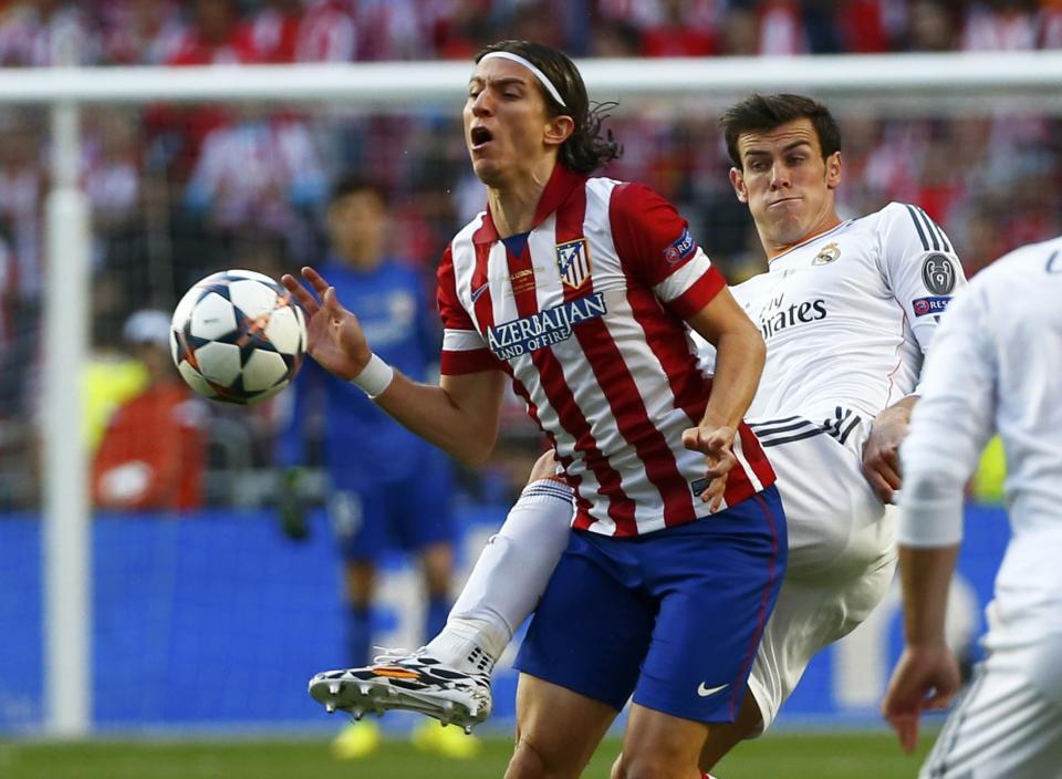 Atletico Madrid's Filipe Luis (L) is challenged by Real Madrid's Gareth Bale during their Champions League final soccer match at Luz stadium in Lisbon, May 24, 2014. REUTERS/Michael Dalder (PORTUGAL - Tags: SPORT SOCCER)