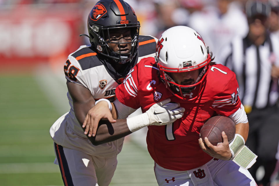 Utah quarterback Cameron Rising battles with Oregon State defensive back Kitan Oladapo before scoring during the first half of an NCAA college football game, Saturday, Oct. 1, 2022, in Salt Lake City. (AP Photo/Rick Bowmer)