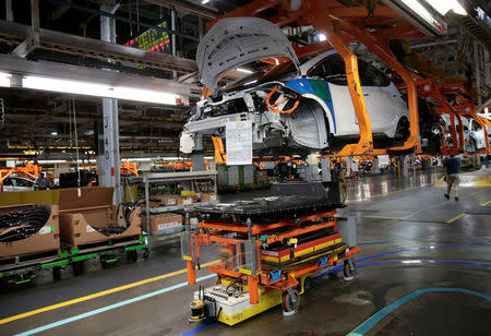 An automated guided vehicle carrying a battery pack moves under a partially assembled 2018 Chevrolet Bolt EV vehicle on the assembly line at General Motors Orion Assembly in Lake Orion, Michigan, U.S., March 19, 2018. REUTERS/Rebecca Cook/Files