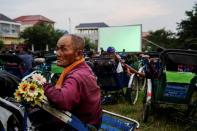 Tricycle drivers attend an outdoor movie screening held by a private organization in Phnom Penh