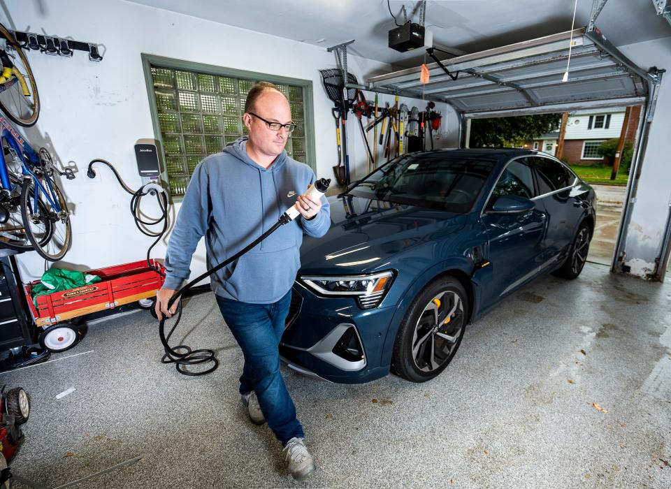 Andrew Tilley gets ready to plug in his Audi e-tron with a Level 2 charger he had installed in the garage of his Wauwautosa home. Level 2 chargers have become the home-charging standard since they can add 25 to 40 miles of driving range an hour.