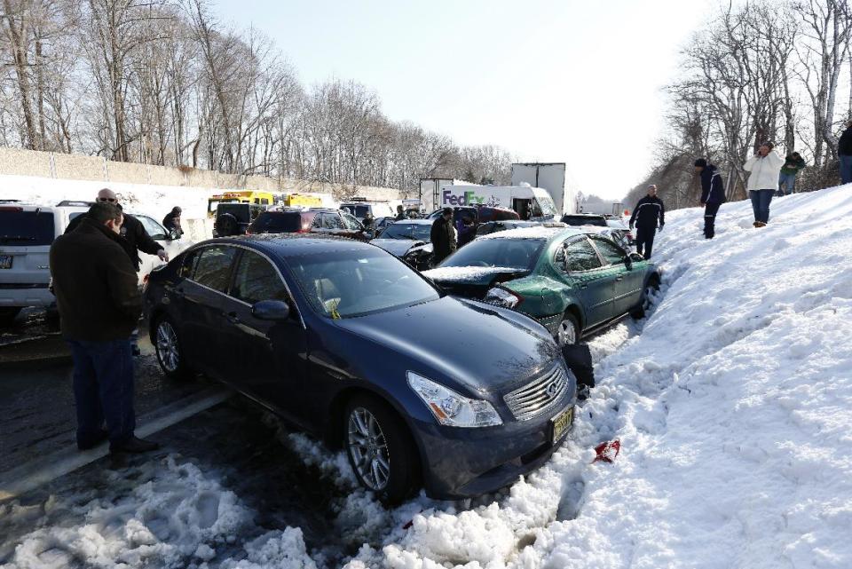 Vehicles are piled up in an accident, Friday, Feb. 14, 2014, in Bensalem, Pa. Traffic accidents involving multiple tractor trailers and dozens of cars have completely blocked one side of the Pennsylvania Turnpike outside Philadelphia and caused some injuries. (AP Photo/Matt Rourke)