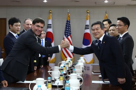 U.S. Defense Secretary Mark Esper clasps hands with South Korean Defense Minister Jeong Kyeong-doo during their meeting in Seoul