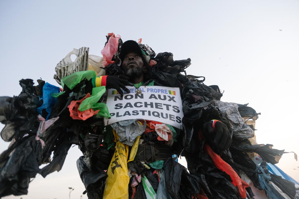 Modou Fall, cuya organización se enfoca en educar a los residentes de Senegal sobre los peligros de la basura de plástico, sostiene un cartel que dice 