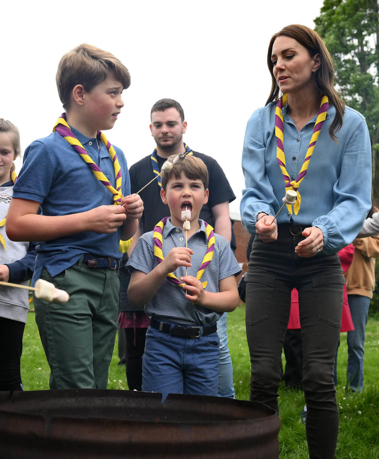 Britain's Prince George of Wales, Britain's Prince Louis of Wales and Britain's Catherine, Princess of Wales toast marshmallows as they take part in the Big Help Out, during a visit to the 3rd Upton Scouts Hut in Slough, west of London on May 8, 2023, where the family joined volunteers helping to renovate and improve the building.  (Daniel Leal / AFP via Getty Images)