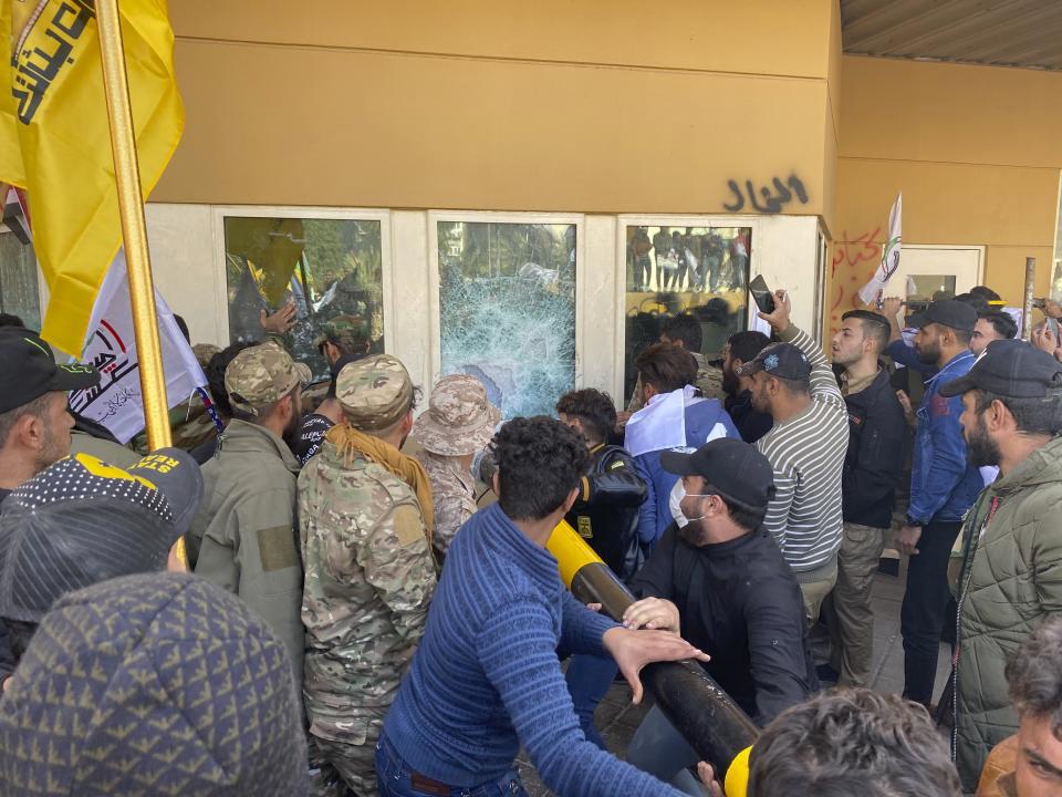 Protesters smash a window inside the U.S. embassy compound, in Baghdad, Iraq, Tuesday, Dec. 31, 2019. Dozens of angry Iraqi Shiite militia supporters broke into the U.S. Embassy compound in Baghdad on Tuesday after smashing a main door and setting fire to a reception area, prompting tear gas and sounds of gunfire. (AP Photo/Khalid Mohammed)