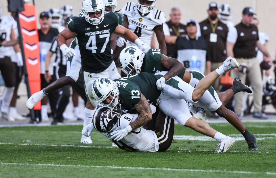 MSU LB Ben VanSumeren (13)   and LB Angelo Grose tackle WMU RB Sean Tyler Friday., Sept. 2, 2022, during the season opener at Spartan Stadium.