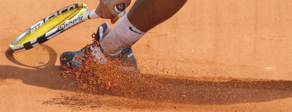 FILE- In this Monday, May 25, 2009, image, Spain's Rafael Nadal slides in the clay as he returns the ball to Brazil's Marcos Daniel during a first round match at the Roland Garros stadium in Paris. Sliding is one of the keys to success at the French Open, with the ability to glide along the ground to reach shots that others can't, is one of the skills that makes Rafael Nadal so successful on clay courts, although the start of the French Open postponed until September because of the coronavirus. (AP Photo/Christophe Ena, File)