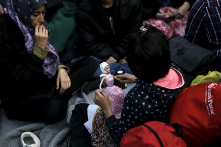 A girl plays with a Barbie doll on Victoria Square, where stranded refugees and migrants, most of them Afghans, find shelter in Athens, Greece, March 3, 2016. REUTERS/Alkis Konstantinidis