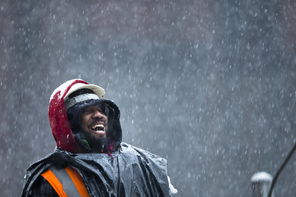 A construction worker smiles as he unloads rebar from a truck during a winter snowstorm, Monday, Feb. 3, 2014, in the Brooklyn borough of New York. After several days of mild weather, snow has returned to the Northeast. (AP Photo/Matt Rourke)