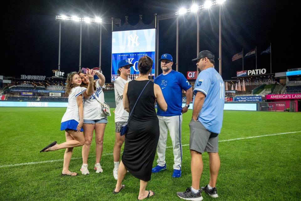 Caroline Garland, 13, from left, and her mother, Cresta Garland, take a selfie on the field, as Kansas City Royals assistant hitting coach Joe Dillion talks with his son, Bray, 15, brother-in-law Tanner Garland, and Tilleri Dillion, Joe’s wife, after the Royals lost to the New York Yankees on Wednesday, June 12, 2024, at Kauffman Stadium.