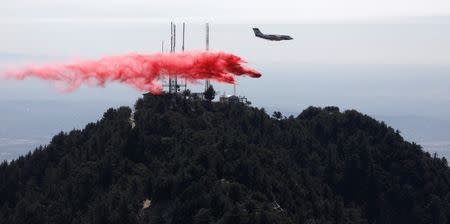 An airplane drops fire retardant while battling the Wilson Fire near Mount Wilson in the Angeles National Forest in Los Angeles, California, U.S. October 17, 2017. REUTERS/Mario Anzuoni