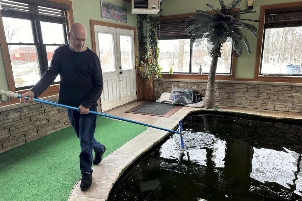 Tony Cavallaro cleans the indoor pool he built for his pet alligator, Albert, on March 19, 2024, Hamburg, N.Y. Albert was seized by the Department of Environmental Conservation in mid-March 2024. (AP Photo/Carolyn Thompson)