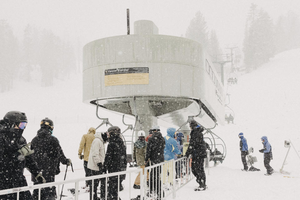 In this photo provided by Mammoth Mountain Ski Area, skiers line up at the Caynon Express high speed chairlift in Mammoth Mountain in Mammoth Lakes, Calif., on Friday, April 15, 2022. California storms have blanketed the Sierra Nevada in snow. Winter isn't quite ready to give up its grip on the Eastern Sierra. Mammoth Mountain is expecting a foot of fresh snow Saturday. (Peter Morning/MMSA via AP)