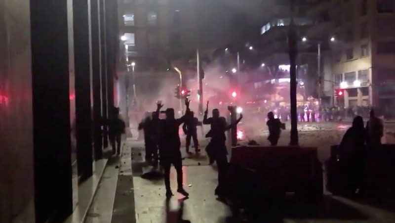 Demonstrator gestures towards riot police in Bogota