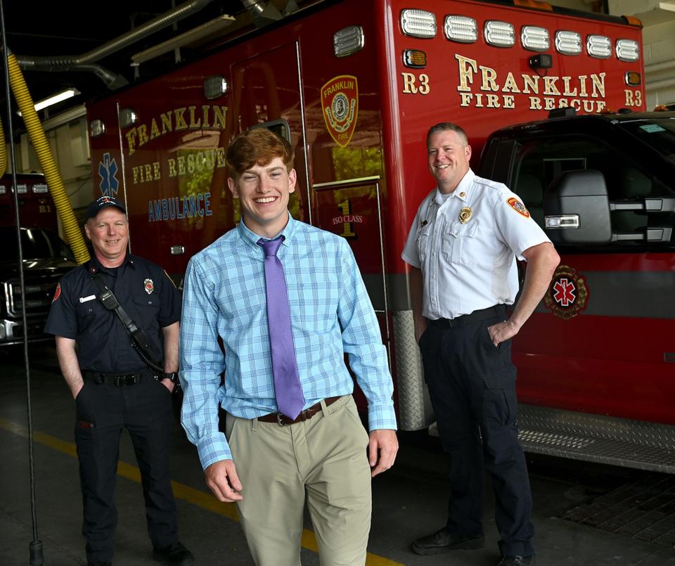 Craig Scharland, 18, of Franklin, center, stands with Franklin Fire Department Battalion Chief Chuck Allen, right, and Capt. Darrel Griffin, the two firefighters who helped deliver him before his ambulance could get to Milford Regional Medical Center on July 23, 2003.