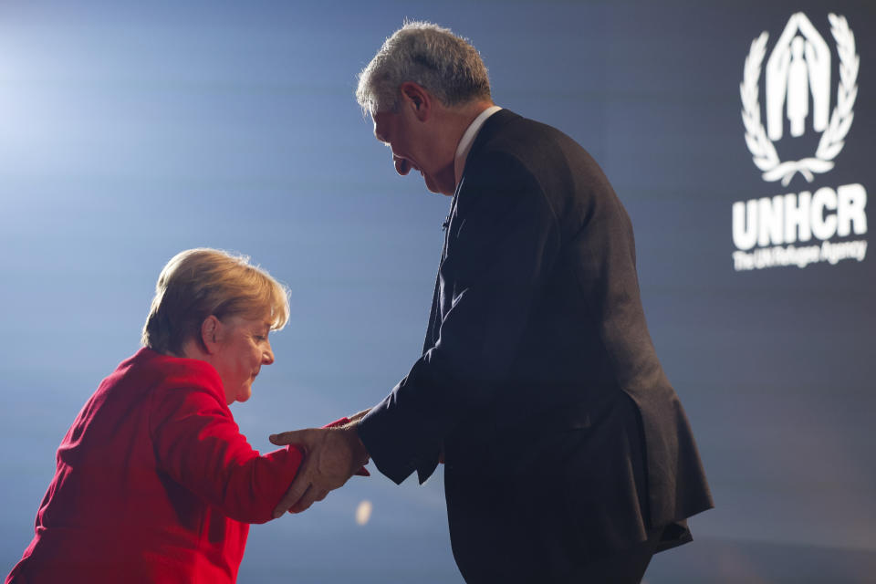 United Nations High Commissioner for Refugees Filippo Grandi helps Angela Merkel on stage to receive the UNHCR Nansen Refugee Award for protecting refugees at the height of the Syria crisis, during a ceremony in Geneva, Switzerland, Monday Oct. 10, 2022. (Stefan Wermuth/Pool via AP)