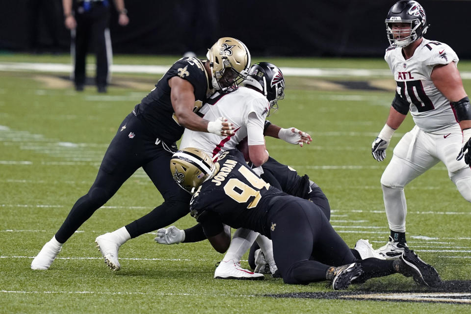 Atlanta Falcons quarterback Matt Ryan is sacked by New Orleans Saints defensive end Cameron Jordan (94) and defensive end Marcus Davenport, musing the Flacons out of field goal range, in the first half of an NFL football game in New Orleans, Sunday, Nov. 22, 2020. (AP Photo/Butch Dill)