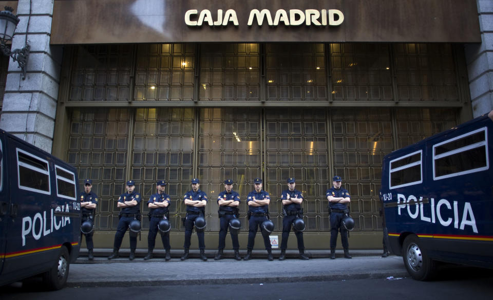 File - In this May 14, 2012 file photo, riot police stand guard in front of a branch of the recently nationalized Caja de Madrid/ Bankia bank in Madrid. Spain's government said Friday Oct. 19, 2012 it is considering a ban on photographing, filming and reproducing images of police and state security forces while “in the exercise of their functions.” Deputy Prime Minister Soraya Saenz de Santamaria said that after months of television and internet viewing of sometimes violent clashes between police and demonstrators a balance had to be struck “between citizens' right to protest” and a need “to uphold the integrity of state security forces.” (Alberto Di Lolli, File)