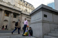 A homeless man sits opposite the Bank of England, as workers make their way into work in the City of London, Britain October 18, 2017. Picture taken October 18, 2017. REUTERS/Mary Turner