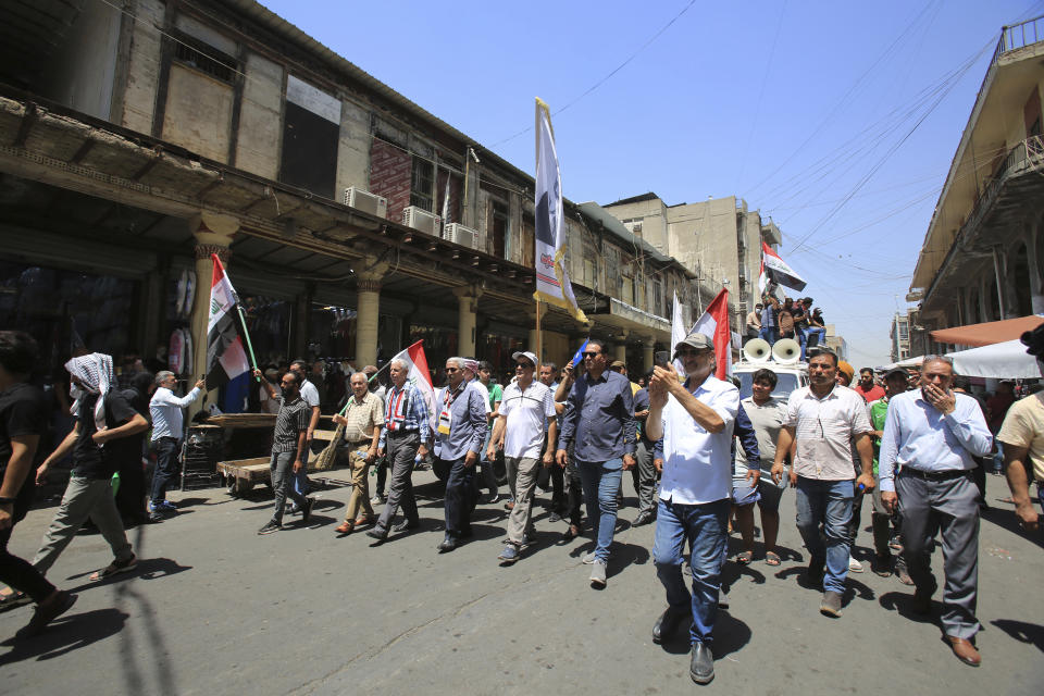 Demonstrators protest in front of the Iraqi central bank as currency plummets against the U.S. dollar, in Baghdad, Iraq, Wednesday, July. 26, 2023. Over the past two days, the market rate of the dollar jumped from 1,470 dinar per dollar to 1,570 dinar per dollar. (AP Photo/Hadi Mizban)