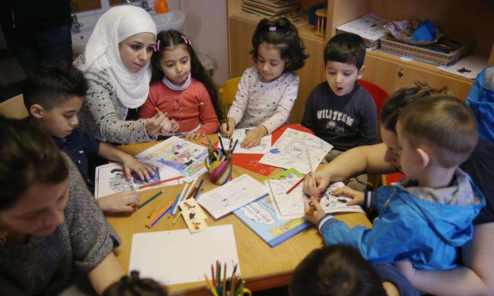 Reading Initiative For Refugee Children LaunchBERLIN, GERMANY - DECEMBER 16: Immigrant mothers with their children look through games and books during the presentation of a new initiative to help children of refugees learn to read German at a shelter for migrants and refugees on December 16, 2015 in Berlin, Germany. The initiative, 