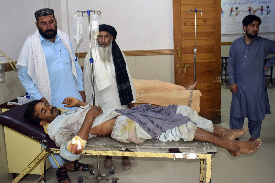 A man injured in a bus accident in Dana Sar, Khyber Pakhtunkhwa province, is treated at a hospital in Quetta, Pakistan, Sunday, July 3, 2022. An official said the passenger bus slid off a mountain road and fell 200 feet (61 meters) into a ravine in heavy rain killing at least 18 people and injuring some 12 others. (AP Photo/Arshad Butt)